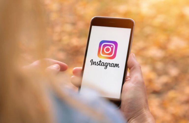 AACHEN, GERMANY AUGUST 2019: Woman holding a Apple iPhone opening Instagram app. Instagram is a social media sharing plattform