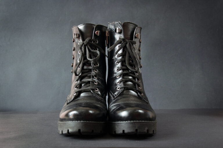 Pair of black rough boots on black background. Modern winter boots
